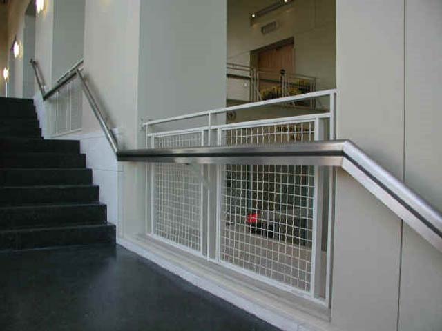 Stainless stair handrail attached to a wall